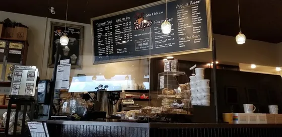 The coffee counter and menu board inside Sips Coffee & Cafe in Rochester, NY